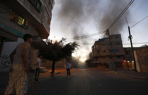 Smoke rises in a Gaza street after IDF air attack. (Photo: AFP) (צילום: AFP) Smoke rises in a Gaza street after IDF air attack. (Photo: AFP)