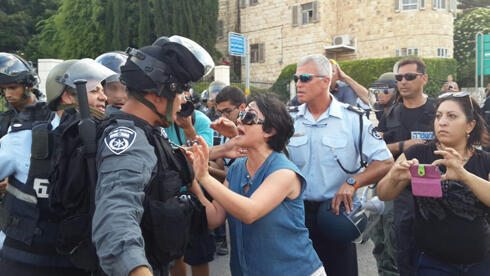 MK Zoabi faces off against riot police at a protest in Haifa. (Photo: Muhammed Shenawi)