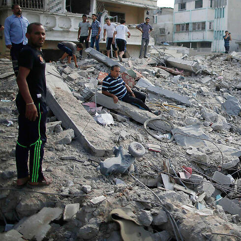Gazans stand in the rubble of a local neighborhood during Saturday's 12-hour long ceasefire. (Photo: Reuters)