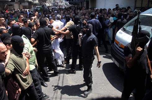 Hamas men following Friday's execution (Photo: AFP)