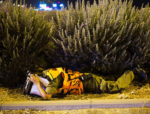 Soldier finding cover during a rocket siren near Ashdod (Photo: Reuters) (צילום: רויטרס) Soldier finding cover during a rocket siren near Ashdod (Photo: Reuters)