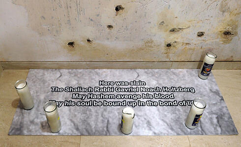 Candles placed around  placard marking spot where Rabbi Holtzberg was killed (Photo: AFP)