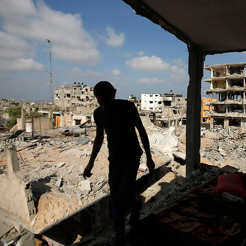 Palestinian man returns to destroyed home in Gaza (Photo: Reuters)