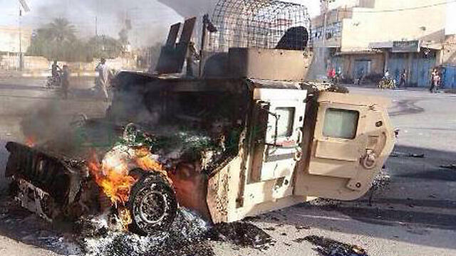 רכב של צבא עיראק עולה באש הוצת על ידי דאעש בעיר היט מחוז אנבאר (צילום: AP) רכב של צבא עיראק עולה באש הוצת על ידי דאעש בעיר היט מחוז אנבאר