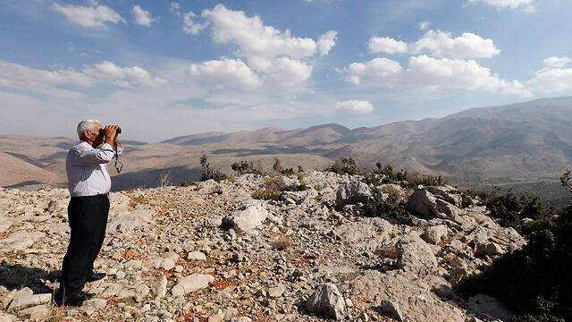 Druze man in Lebanon looking across the border at Syria to watch ongoing fighting (Photo: Reuters)