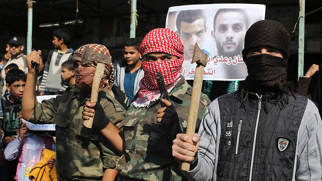 Youths in Gaza pose with axes while celebrating attack (Photo: Reuters)