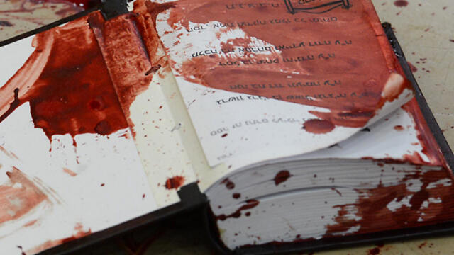 A bloodstained prayer book at the synagogue (Photo: GPO) (צילום: קובי גדעון, לע"מ) A bloodstained prayer book at the synagogue (Photo: GPO)