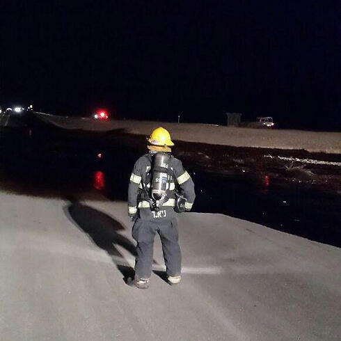 Firefighter works to stop oil spill in southern Israel. (Photo: Police Spokesman's Unit) (צילום: חטיבת דובר המשטרה) Firefighter works to stop oil spill in southern Israel. (Photo: Police Spokesman's Unit)