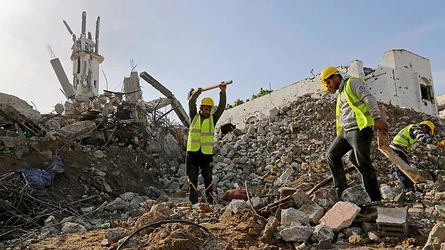 Palestinian workers breaking down rubble (Photo: AP) (צילום: AP) Palestinian workers breaking down rubble (Photo: AP)