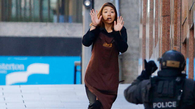 A hostage runs toward police as she flees the siege at a Sydney coffee shop. (Photo: Reuters) (צילום: רויטרס) A hostage runs toward police as she flees the siege at a Sydney coffee shop. (Photo: Reuters)