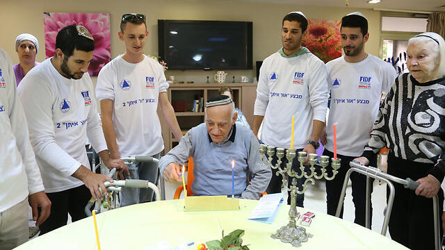 Released IDF soldiers light first candle of Hanukkah at the Gil Oz retirement home in Petah Tikva. (Photo: Yaron Brenner) (צילום: ירון ברנר) Released IDF soldiers light first candle of Hanukkah at the Gil Oz retirement home in Petah Tikva. (Photo: Yaron Brenner)