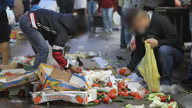 Elderly Israelis pick food from market floor in Tel Aviv (Photo: Ido Erez)