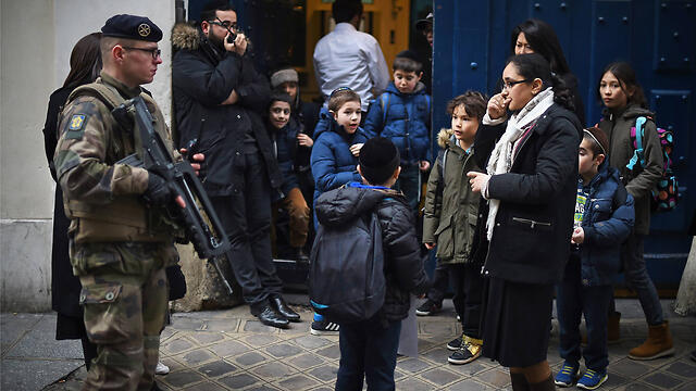 Armed soldiers stand guard outside a Jewish school in Paris last year (Photo:gettyimages)