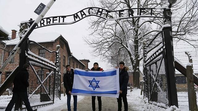 Visitors hold Israeli flag at entrance of Auschwitz (Photo: Reuters) (Photo: Reuters) Visitors hold Israeli flag at entrance of Auschwitz (Photo: Reuters)