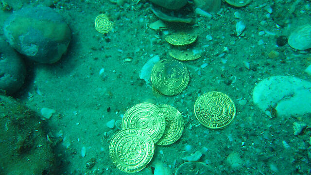The divers 'at first they thought they had spotted a toy coin from a game' (Photo: AFP/Israel Antiquities Authority) (צילום: AFP PHOTO / ISRAEL ANTIQUITIES AUTHORITY / KOBI SHARVIT) The divers 'at first they thought they had spotted a toy coin from a game' (Photo: AFP/Israel Antiquities Authority)