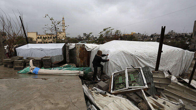 Rain-proofing a makeshift shelter in Gaza (Photo: AFP) (צילום: AFP) Rain-proofing a makeshift shelter in Gaza (Photo: AFP)