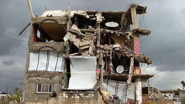 Makeshift dwelling in bombed-out building (Photo: Reuters) (צילום: רויטרס) Makeshift dwelling in bombed-out building (Photo: Reuters)