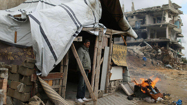 Man outside his makeshift dwellling (Photo: Reuters) (צילום: רויטרס) Man outside his makeshift dwellling (Photo: Reuters)