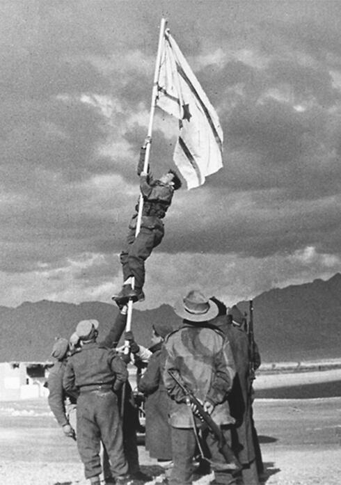 Historic photo shows Avraham Adan hanging the flag (Photo: Micha Perry, IDF Archives Ministry of Defense)