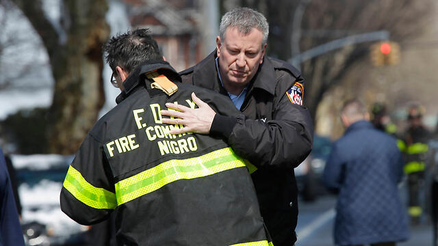 Mayor De Blasio hugs fire fighter. (Photo: Associated Press)