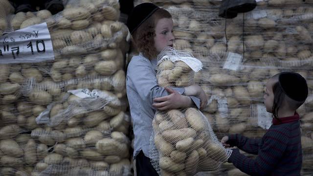 An Ultra-Orthodox Jewish boy carries a bag of potatoes to be distributed to people in need during the preparations for Passover in the Mea Shearim neighborhood of Jerusalem (Photo: EPA) (EPA) An Ultra-Orthodox Jewish boy carries a bag of potatoes to be distributed to people in need during the preparations for Passover in the Mea Shearim neighborhood of Jerusalem (Photo: EPA)