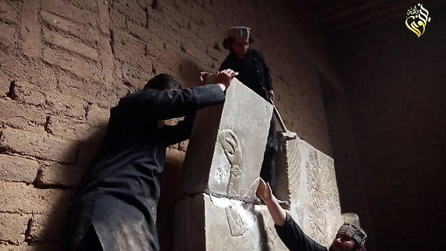 Militants destroying a relief (Photo: AFP) (צילום: AFP / WELAYAT NINEVEH) Militants destroying a relief (Photo: AFP)