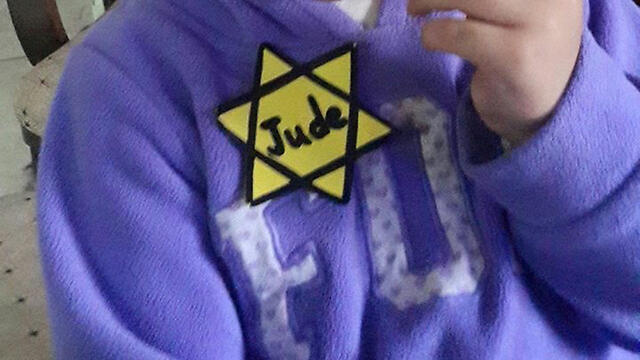 The yellow Star of David attached to the toddlers' clothes.nullnull The yellow Star of David attached to the toddlers' clothes.