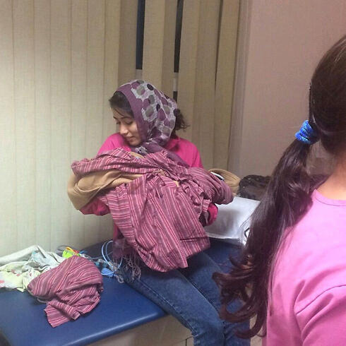 Nepalese nurse with a surrogate baby, following the earthquake (Photo: Shaul Shar) (צילום: שאול שר) Nepalese nurse with a surrogate baby, following the earthquake (Photo: Shaul Shar)