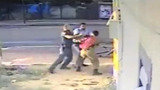 Police officers attacking an Israeli soldier of Ethiopian origin