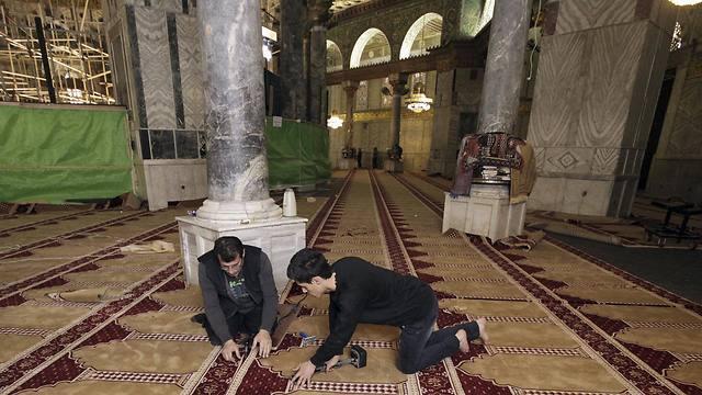 Workers place new carpets at the Dome of the Rock shrine in Jerusalem (Photo: AP)