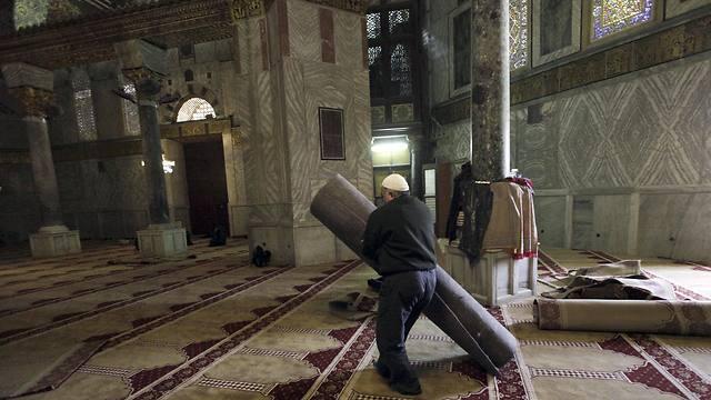 A worker carries new carpets at the Dome of the Rock shrine (Photo: AP)