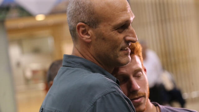 Patrick Asraf embraces his son's comrade upon arrival at Ben-Gurion Airport (Photo: Motti Michi) (צילום: מוטי קמחי) Patrick Asraf embraces his son's comrade upon arrival at Ben-Gurion Airport (Photo: Motti Michi)