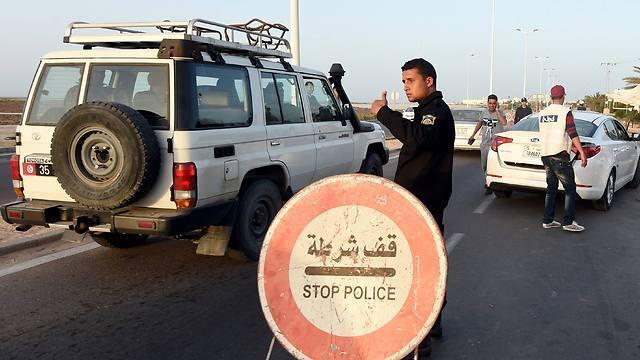 A Tunisian policeman controls cars at a checkpoint on the road to the tourist area in Houmt Souk (Photo: AFP) (צילום: AFP) A Tunisian policeman controls cars at a checkpoint on the road to the tourist area in Houmt Souk (Photo: AFP)