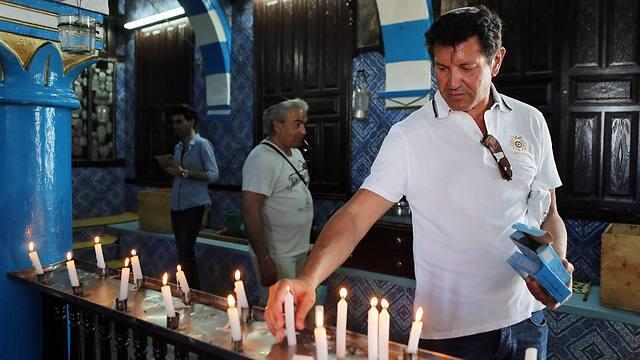 A Jewish visitor lights a candle at the ancient Ghriba Synagogue (Photo: EPA) (צילום: EPA) A Jewish visitor lights a candle at the ancient Ghriba Synagogue (Photo: EPA)