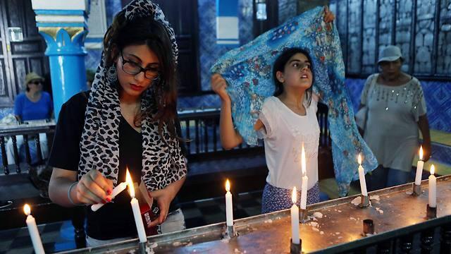 Visitors lighting a candle inside the ancient Ghriba Synagogue (Photo: EPA) (צילום: EPA) Visitors lighting a candle inside the ancient Ghriba Synagogue (Photo: EPA)