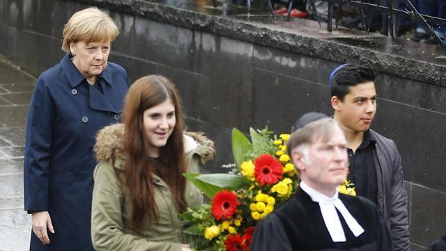 Merkel follows youths carrying flowers on memorial site for former Nazi concentration camp in Dachau (Photo: AP) (Associated Press) Merkel follows youths carrying flowers on memorial site for former Nazi concentration camp in Dachau (Photo: AP)