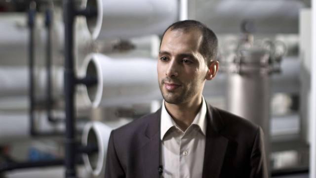 Palestinian engineer Diaa Abu Assi in front of a machine that makes seawater potable (Photo: AFP)