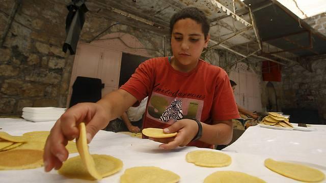 Palestinian Boy sorts Ramadan sweets in Hebron (Photo:Reuters)
