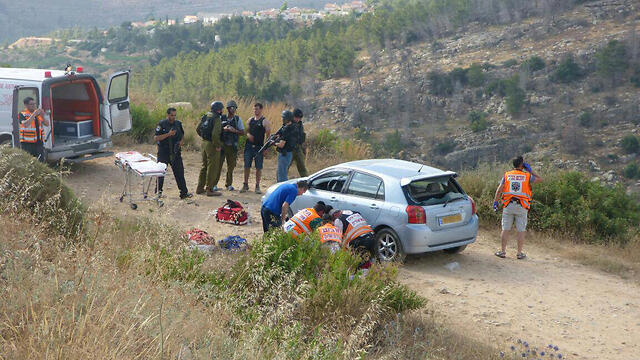 Paramedics attempt to save the life of Danny Gonen after the terror attack. (Photo: Tazpit News Agency)