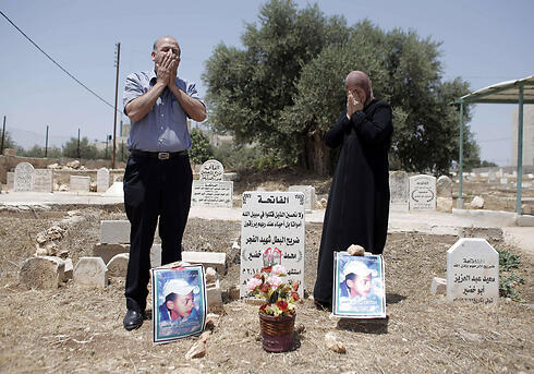 Abu Khdeir's parents mourn at his grave (Photo: AFP) (צילום: AFP) Abu Khdeir's parents mourn at his grave (Photo: AFP)
