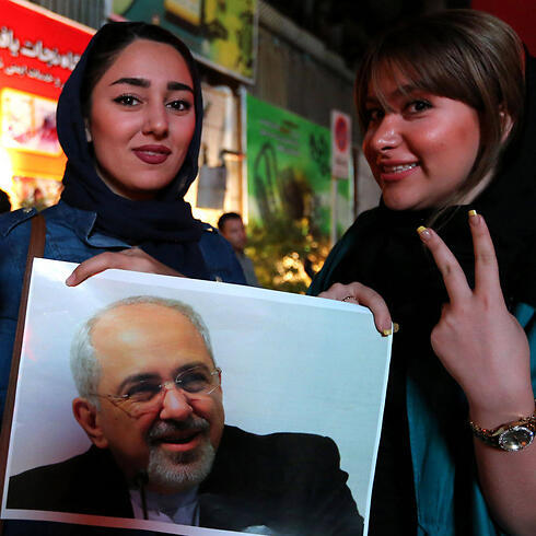 Iranians celebrating with a picture of President Hassan Rouhani (Photo: AFP)