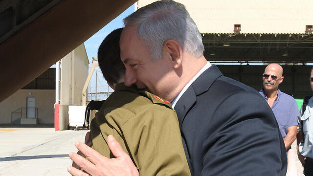 PM Netanyahu embracing Shalit on his release. The price paid for the soldier was too steep, Olmert said