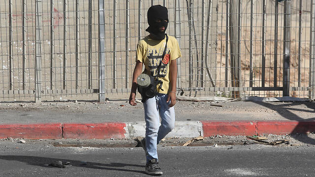 Masked boy with gas mask in Shuafat during disturbances this week (Photo: Gil Yohanan) (צילום: גיל יוחנן) Masked boy with gas mask in Shuafat during disturbances this week (Photo: Gil Yohanan)