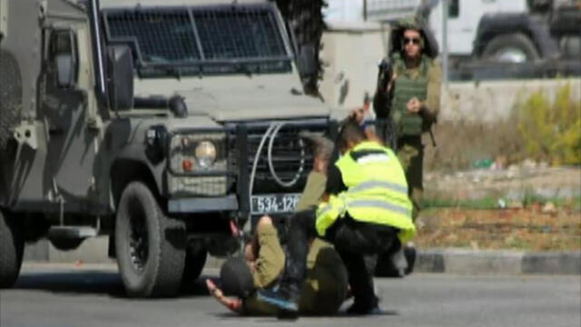 The Palestinian attacker stabbing a soldier on the ground.nullnull The Palestinian attacker stabbing a soldier on the ground.