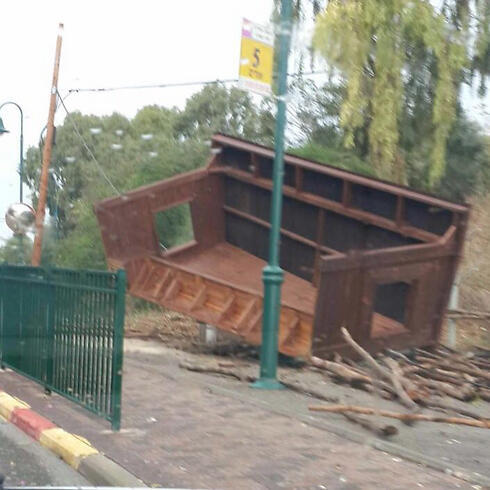 Strong winds uproot bus stop in Moshav Udim.