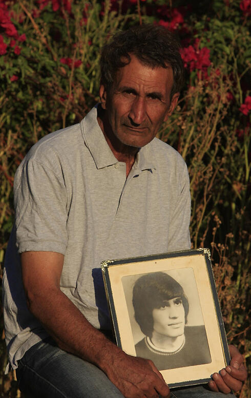 Haim Shahar and a photo of his brother, Eliyahu Shahar, who was murdered in the 1979 terror attack (Photo: Tsafrir Abayov)