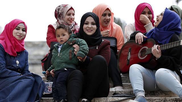 Young Palestinian women listen to one of them playing the guitar outside of the Church of the Nativity (Photo: Reuters) (Reuters) Young Palestinian women listen to one of them playing the guitar outside of the Church of the Nativity (Photo: Reuters)