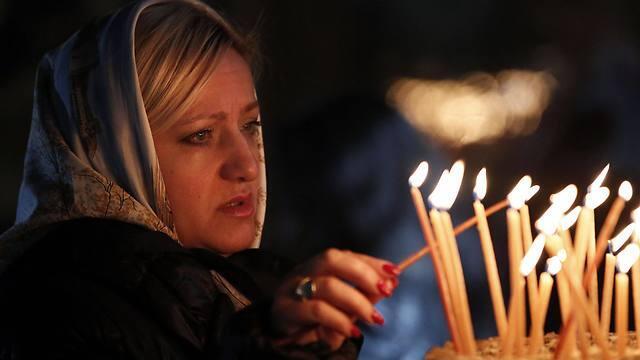 A Christian worshipper lights a candle at the Church of the Nativity (Photo: AFP) (AFP) A Christian worshipper lights a candle at the Church of the Nativity (Photo: AFP)