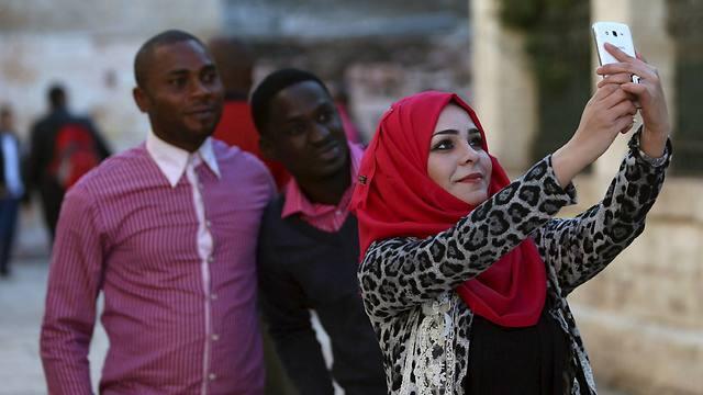 A Palestinian woman takes a selfie with tourists outside the Church of Nativity (Photo: Reuters) (Reuters) A Palestinian woman takes a selfie with tourists outside the Church of Nativity (Photo: Reuters)