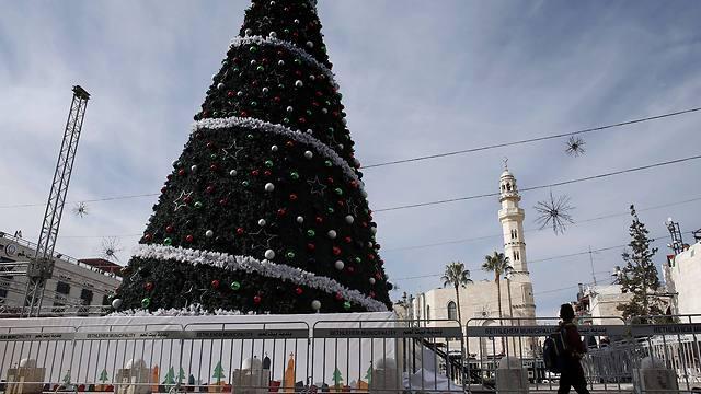 Boy walking past a Christmas tree and the mosque on the Manger Square (Photo: AFP) (AFP) Boy walking past a Christmas tree and the mosque on the Manger Square (Photo: AFP)